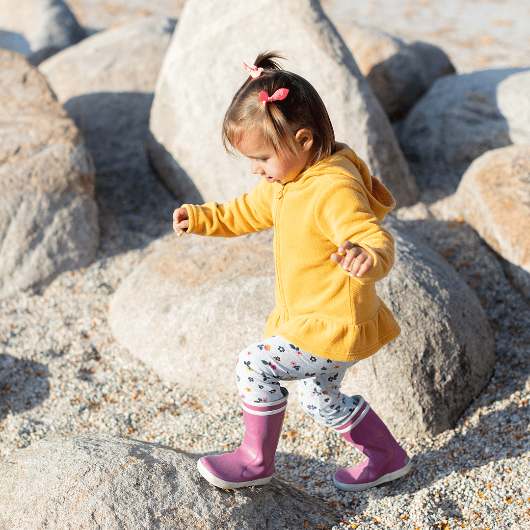 Girl balancing on stones – kids’ movement that improves balance and coordination
