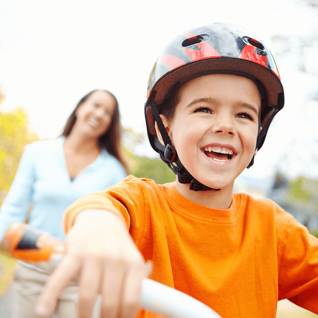 Boy and mom cycling outdoors – physical activity for kids in nature